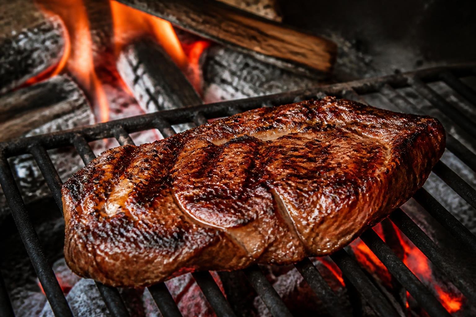 Viande maturée grillée au feu de bois avec croûte caramélisée et marques de chaleur