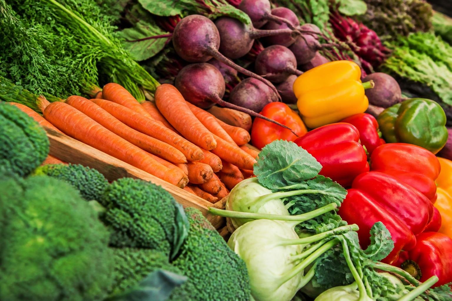 Détail de légumes frais colorés à un marché, illustrant le choix de produits de saison
